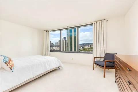 a bedroom with a bed and a large window