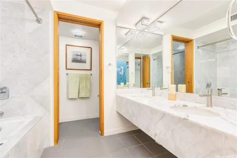 a spacious bathroom with a tub sink and mirror