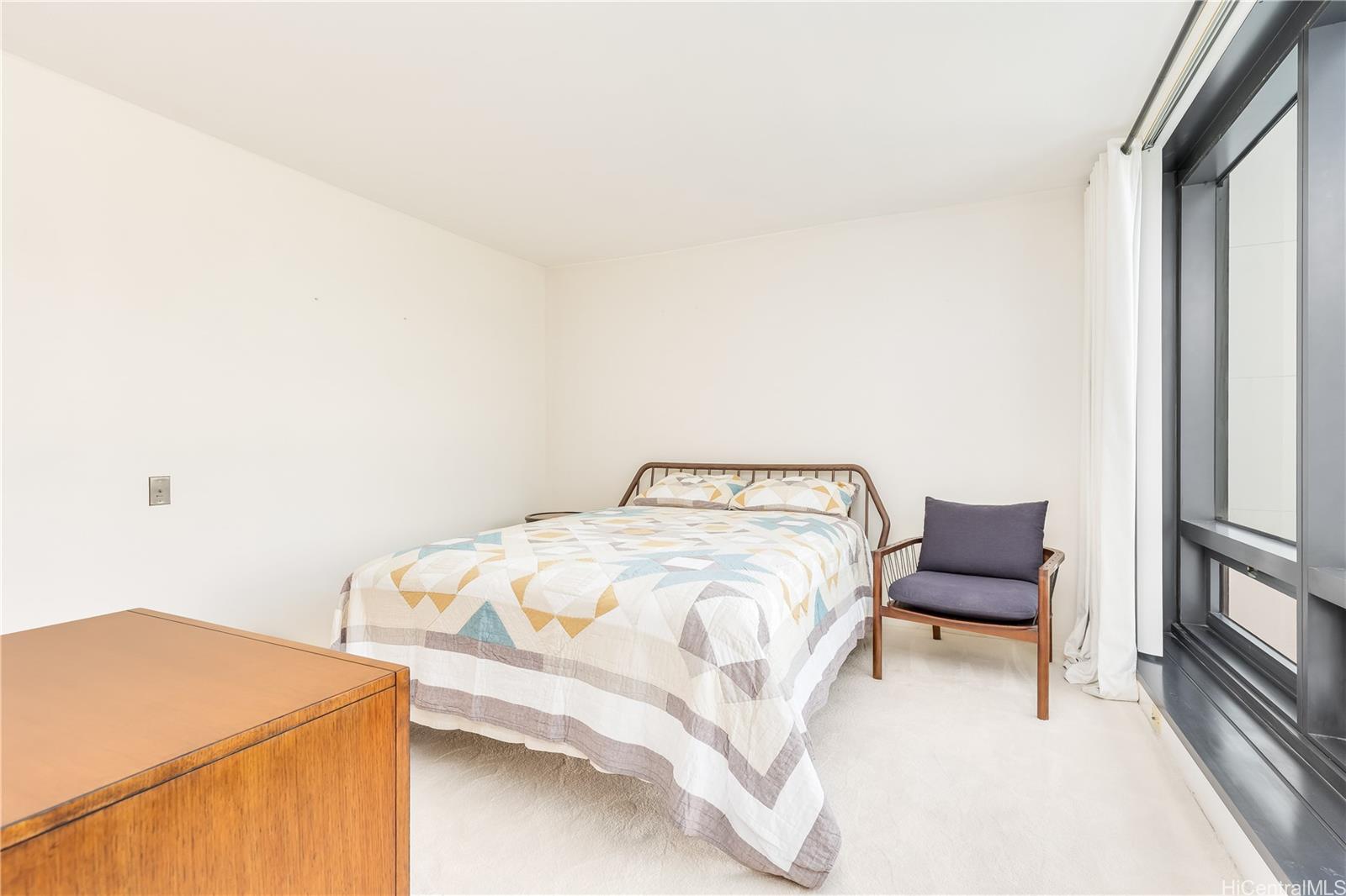 1330 Ala Moana Boulevard, Unit 1308 Honolulu, HI 96814 - Photo 9 of 24 a bedroom with a bed and a chair