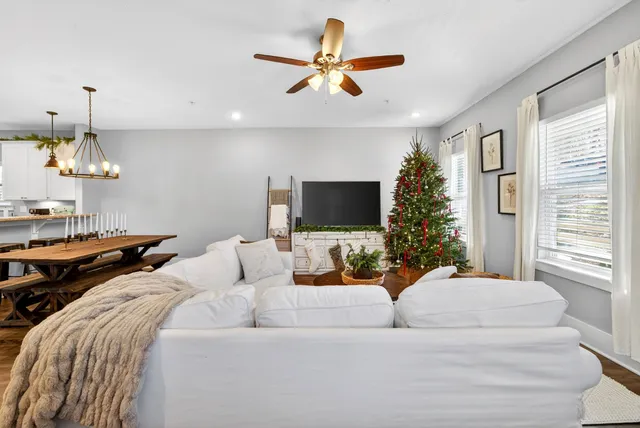 a living room with furniture ceiling fan and a window