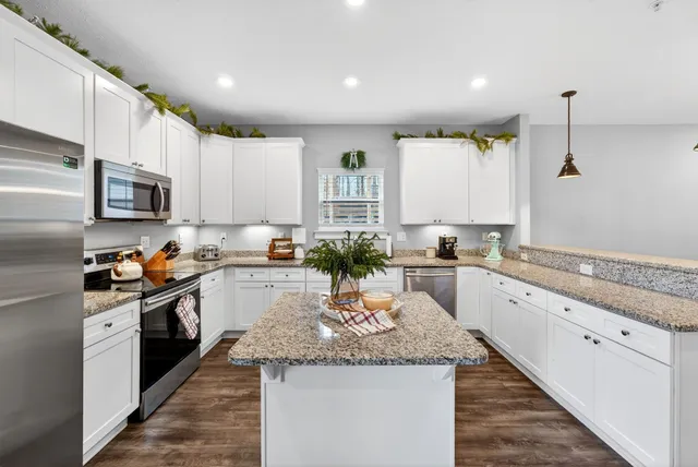 a kitchen with granite countertop white cabinets and white appliances