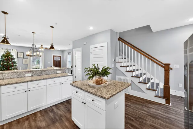 a kitchen with granite countertop cabinets a sink and a wooden floor