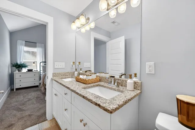 a bathroom with a sink a toilet and a mirror