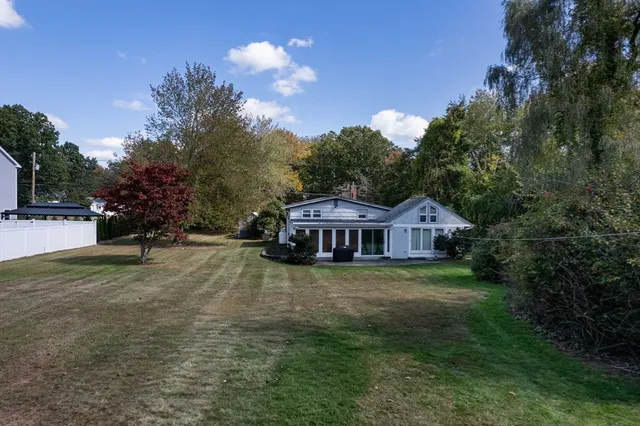 a front view of a house with a yard and trees
