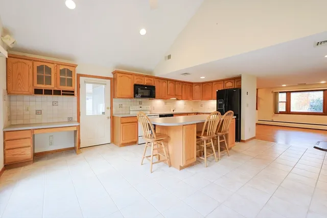 a kitchen with stainless steel appliances a stove a sink a oven a dining table and chairs