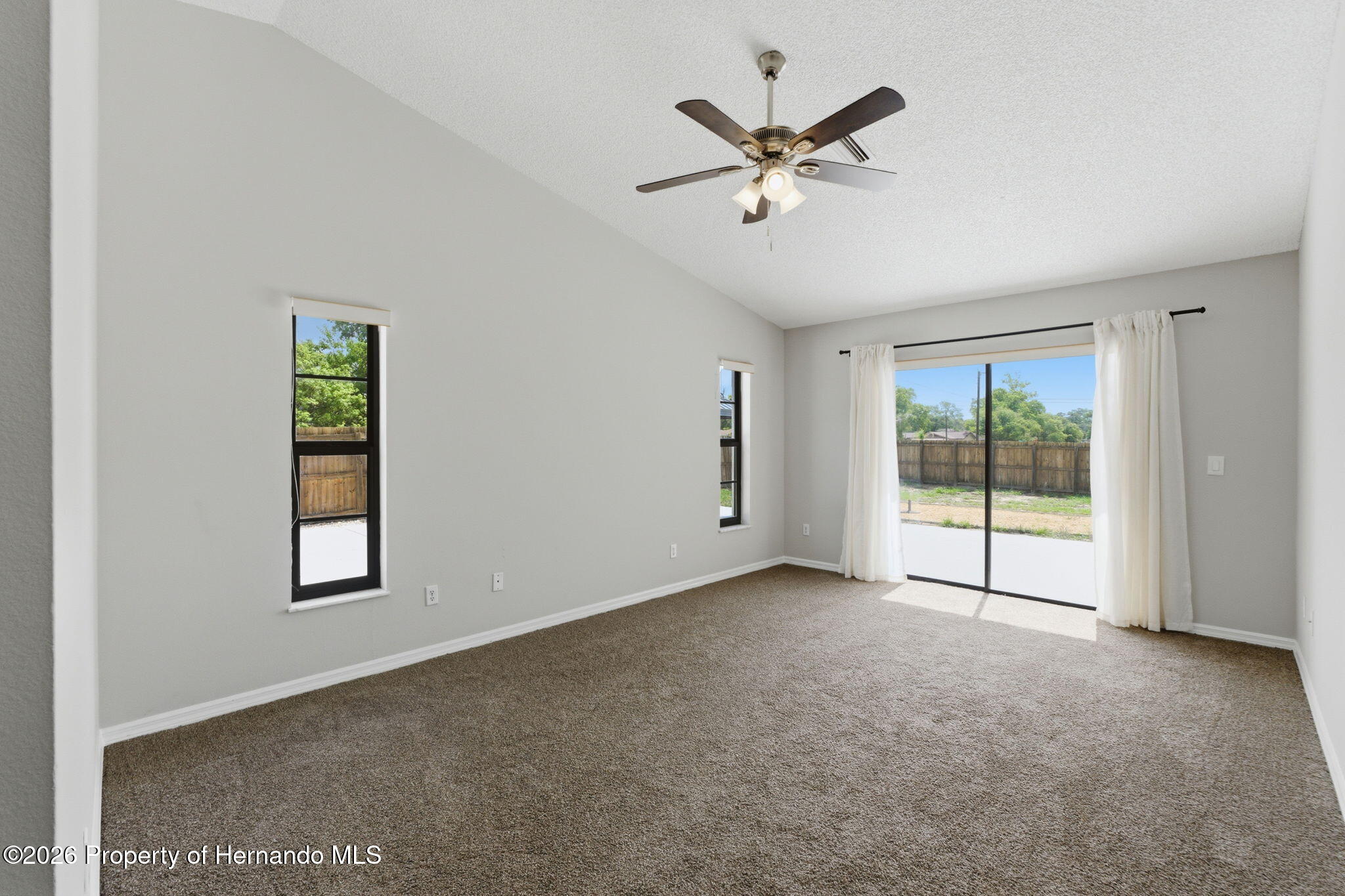 4966 Keysville Avenue Spring Hill, FL 34608 - Photo 26 of 50 a view of a big room with windows and chandelier fan
