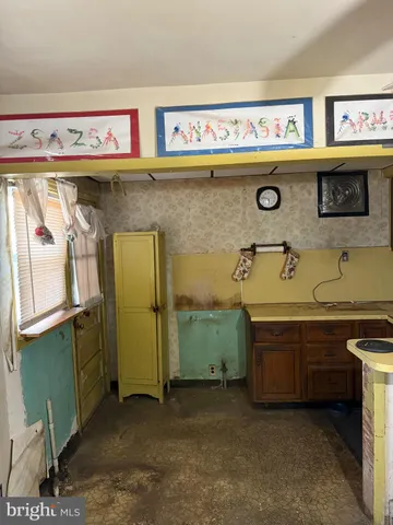 a utility room with stainless steel appliances a sink and cabinets