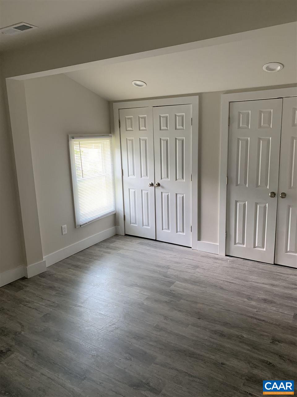 1109 Myrtle Street, Unit B Charlottesville, VA 22902 - Photo 6 of 14 an empty room with wooden floor and windows