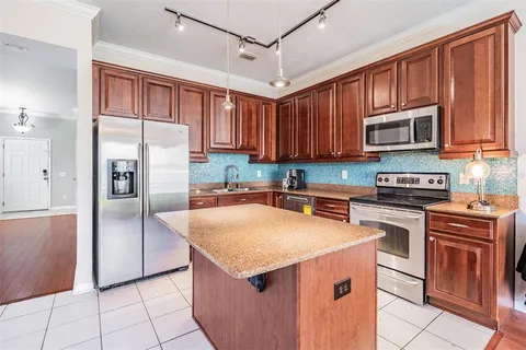 a kitchen with stainless steel appliances granite countertop a refrigerator stove and sink