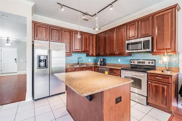 a kitchen with stainless steel appliances granite countertop a refrigerator stove and sink