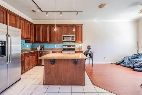 a kitchen with stainless steel appliances granite countertop a stove a sink dishwasher and a refrigerator