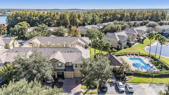 an aerial view of a house with a yard swimming pool and lake view