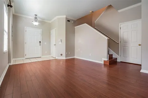 an empty room with wooden floor and entryway