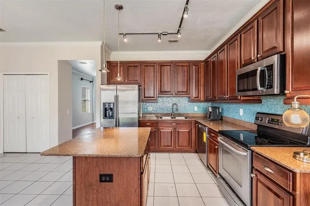 a kitchen with stainless steel appliances granite countertop a sink stove microwave and refrigerator
