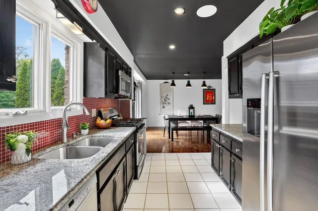a kitchen with stainless steel appliances granite countertop a sink stove and refrigerator