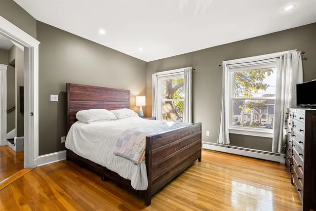 a bedroom with a bed and a flat tv screen next to a window