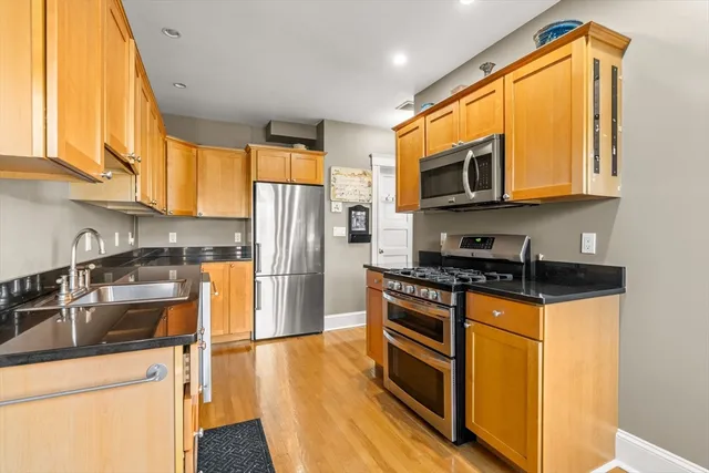 a kitchen with stainless steel appliances granite countertop a stove a sink and a refrigerator