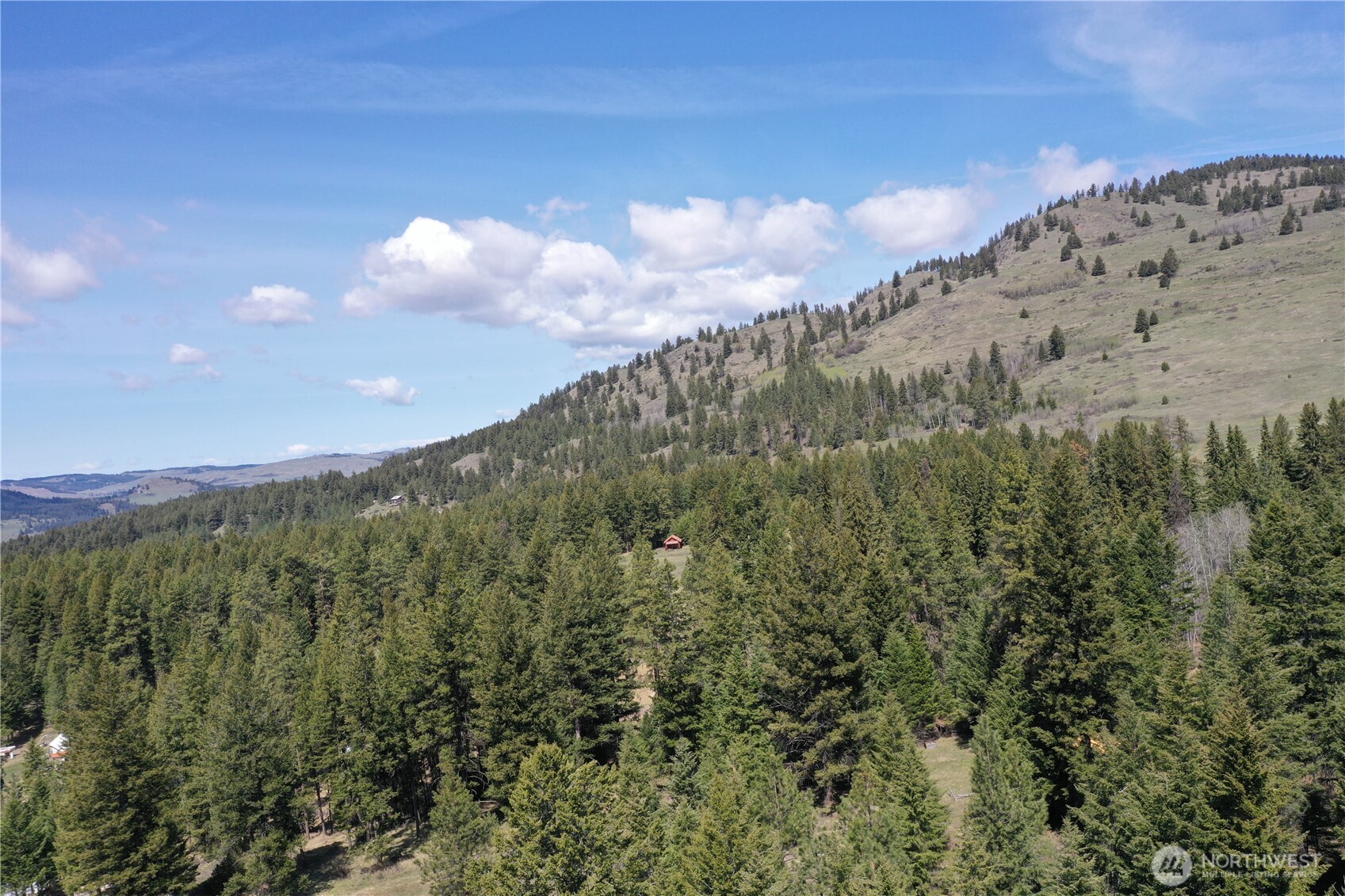 65A Spring Meadow Lane Oroville, WA 98844 - Photo 18 of 40 a view of a large building with mountains in the background
