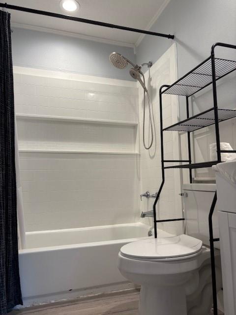 401 Reynolds Road Athens, TX 75751 - Photo 14 of 15 Full bathroom featuring a white tub and shower combination with a tiled surround, a chrome showerhead with an attached handheld sprayer, a white toilet, and wood-finish flooring