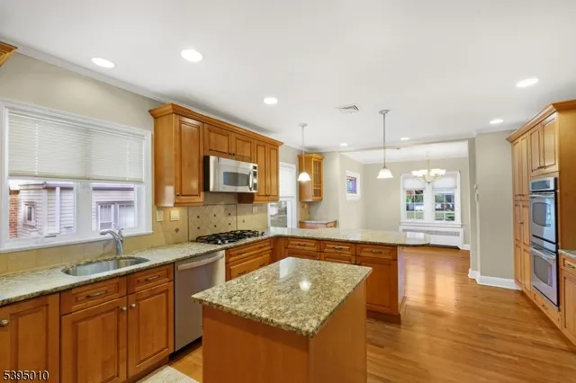 a large kitchen with stainless steel appliances granite countertop a sink and a stove top oven