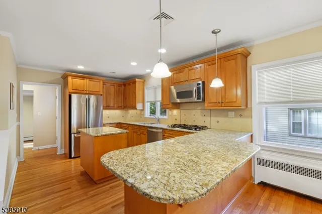 a kitchen with stainless steel appliances granite countertop wooden cabinets a oven and a granite counter top