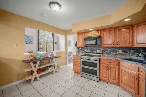 a kitchen with granite countertop a stove top oven and cabinets