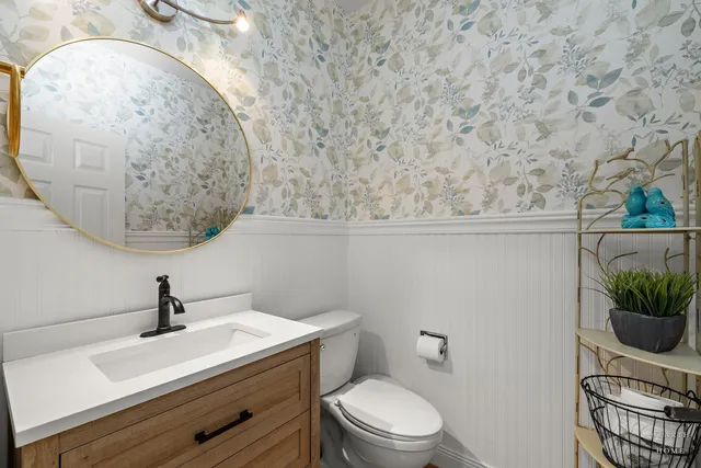 a bathroom with a toilet a sink and mirror