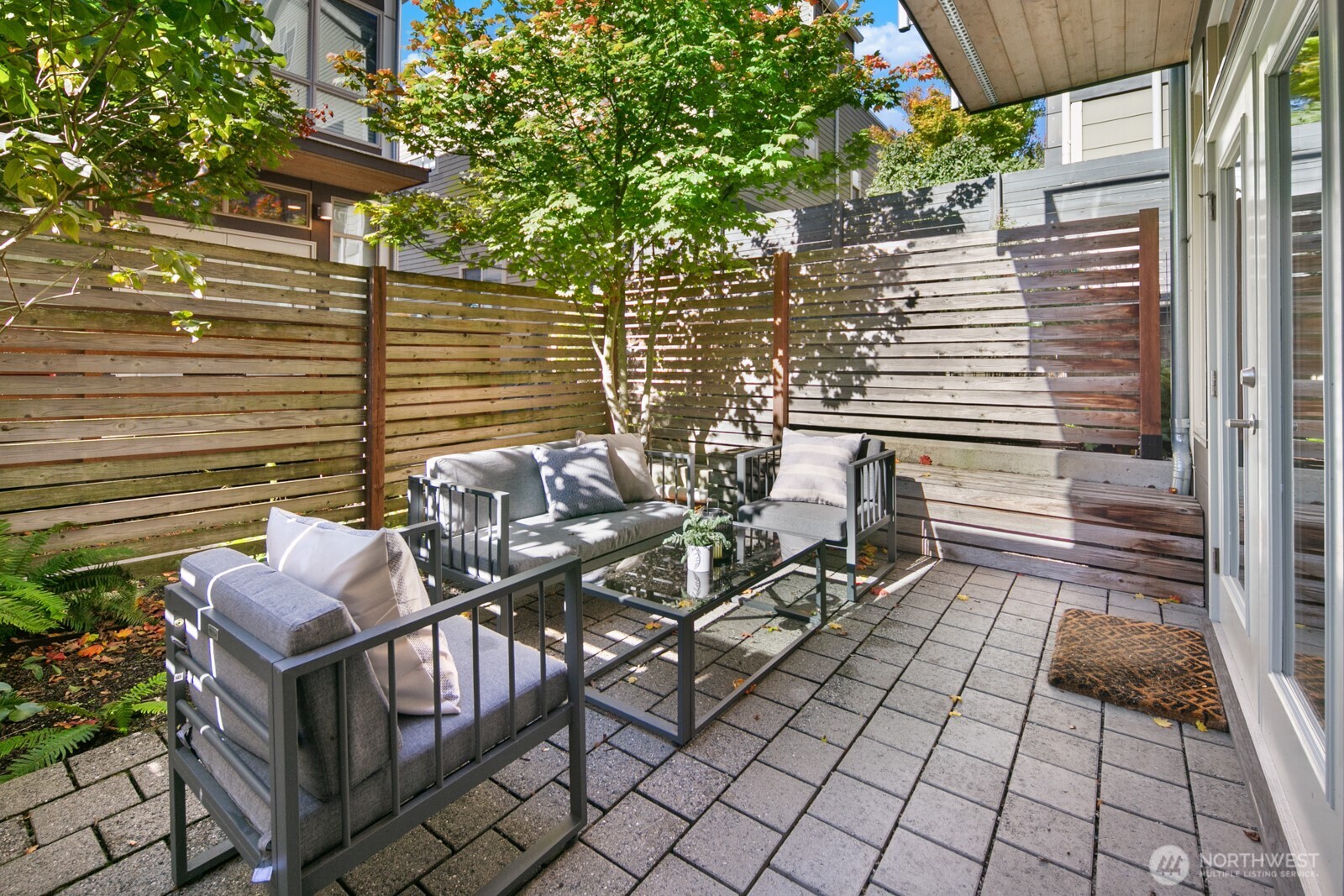 2808 14th Avenue West, Unit B Seattle, WA 98119 - Photo 31 of 39 a view of a patio with table and chairs with wooden floor and fence
