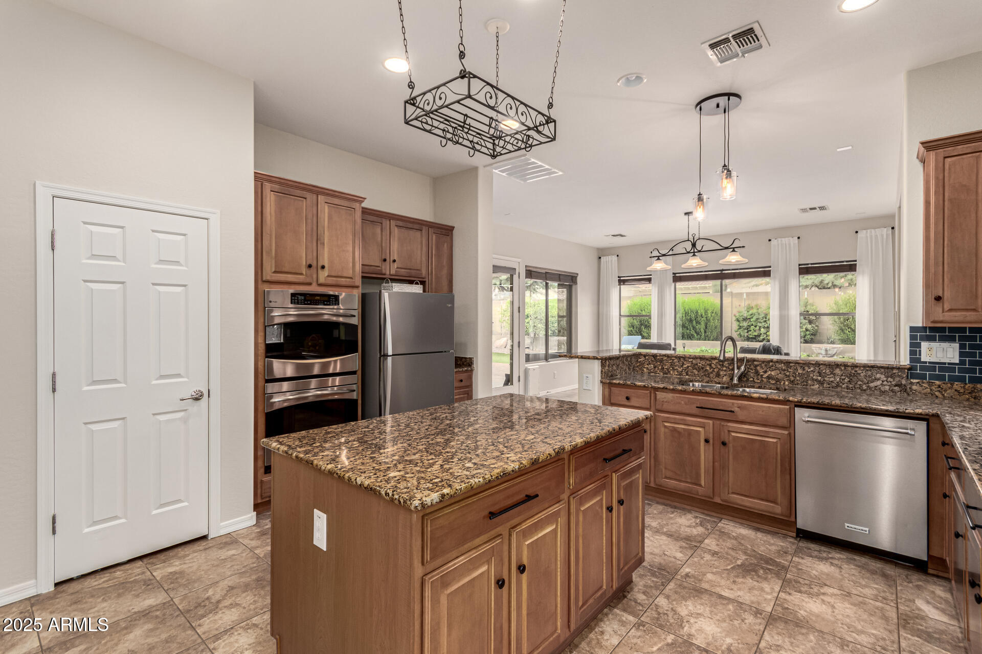 4808 West Cavalry Road Phoenix, AZ 85087 - Photo 13 of 67 a kitchen with stainless steel appliances granite countertop a sink and a refrigerator