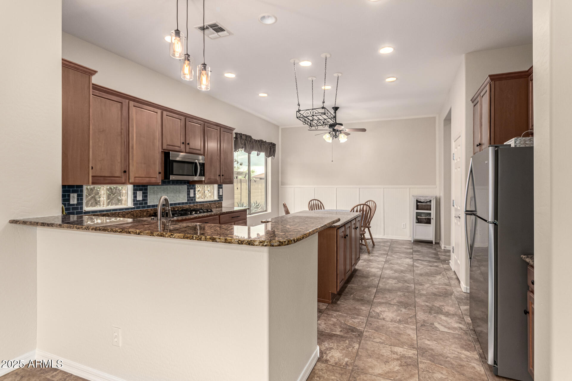 4808 West Cavalry Road Phoenix, AZ 85087 - Photo 17 of 67 a kitchen with kitchen island granite countertop a sink and refrigerator