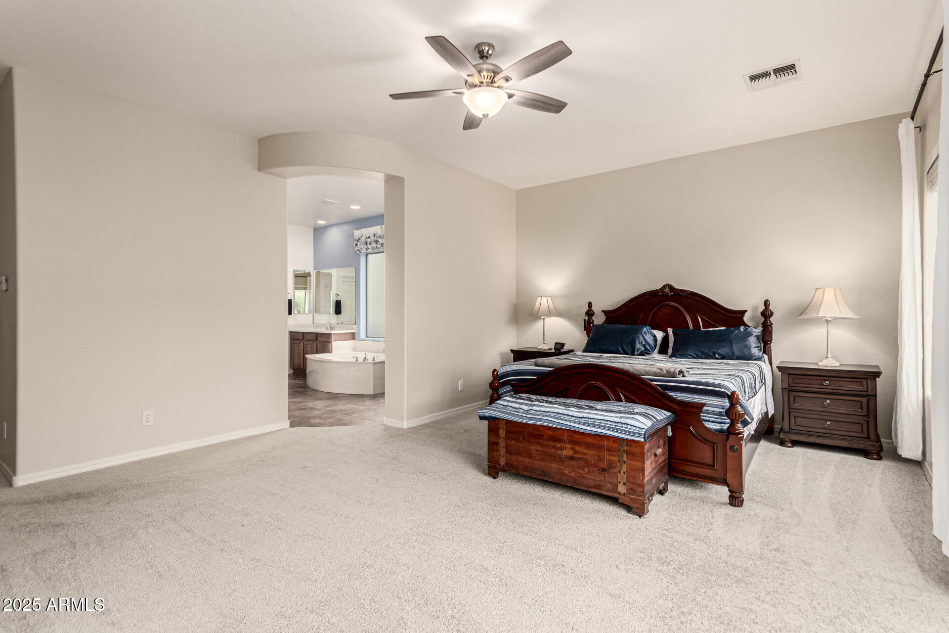 4808 West Cavalry Road Phoenix, AZ 85087 - Photo 22 of 67 a spacious bedroom with a bed and a chandelier