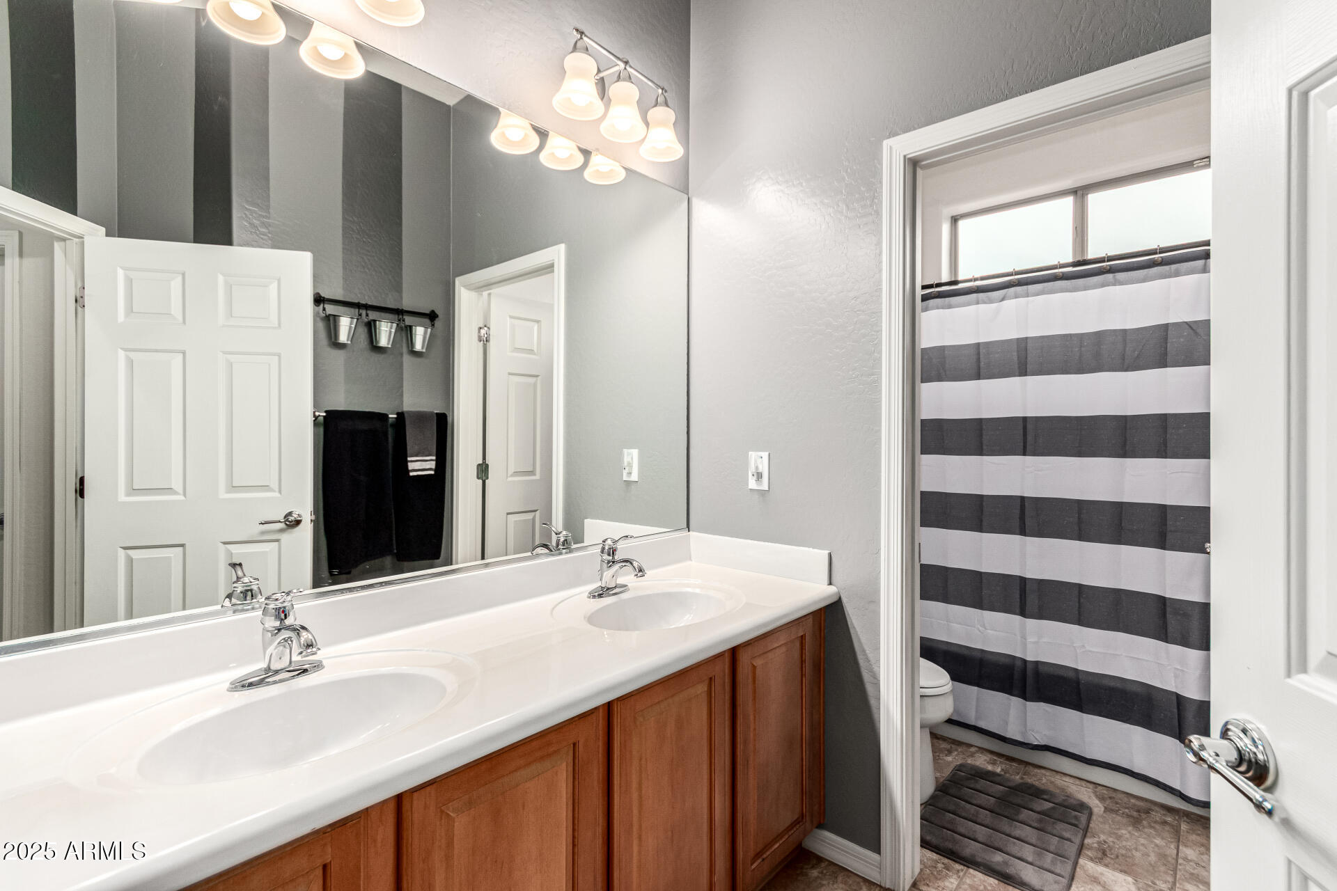 4808 West Cavalry Road Phoenix, AZ 85087 - Photo 35 of 67 a bathroom with a double vanity sink and a mirror