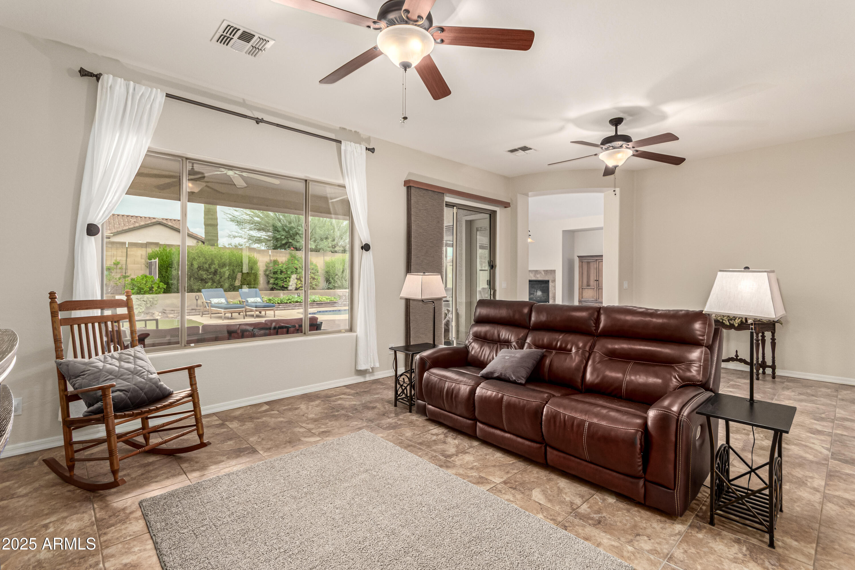 4808 West Cavalry Road Phoenix, AZ 85087 - Photo 8 of 67 a living room with furniture a ceiling fan and a large window