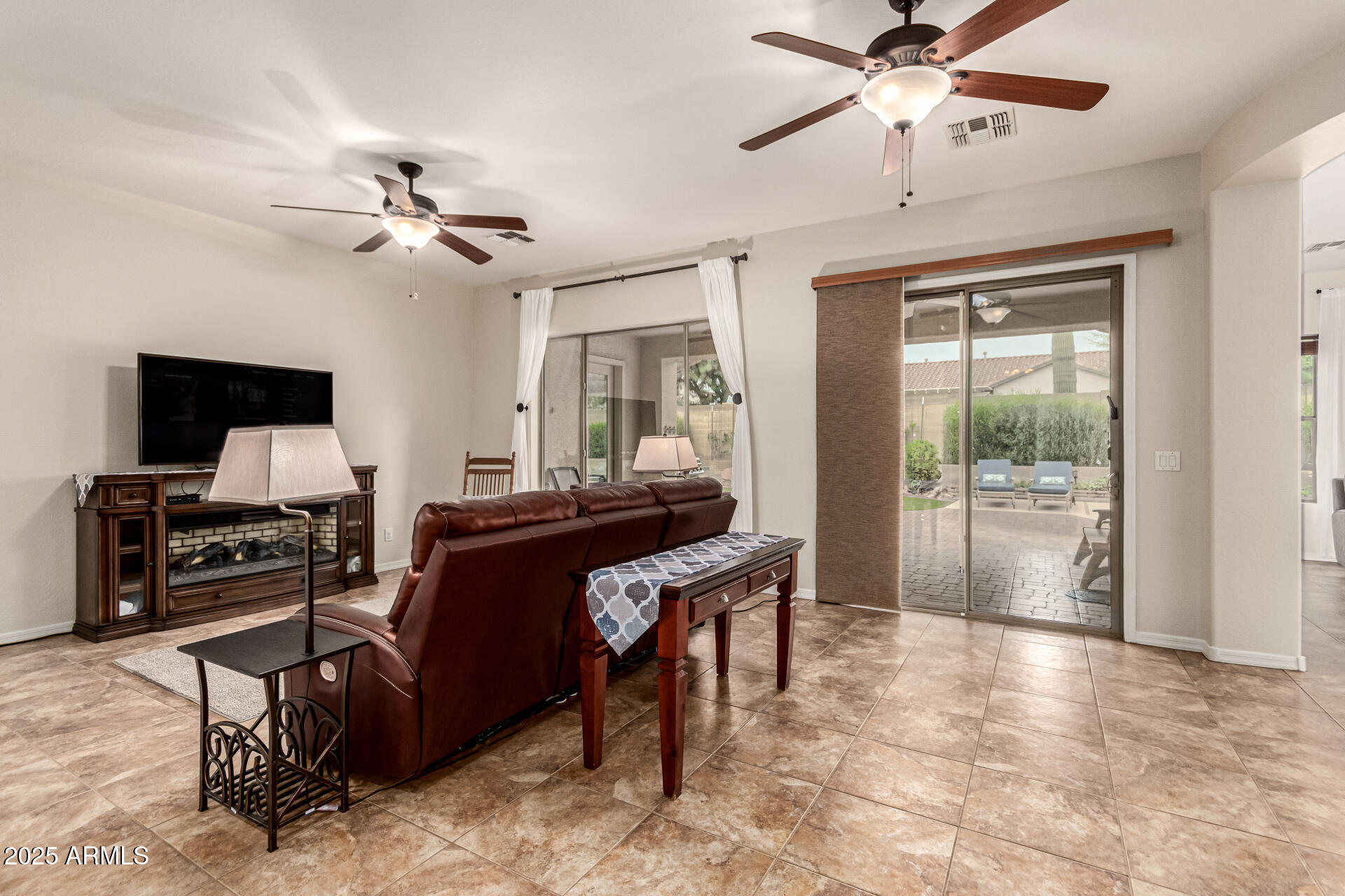 4808 West Cavalry Road Phoenix, AZ 85087 - Photo 9 of 67 a living room with furniture a dining table and a flat screen tv with wooden floor