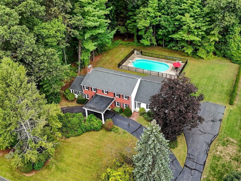 an aerial view of a house with a yard and swimming pool
