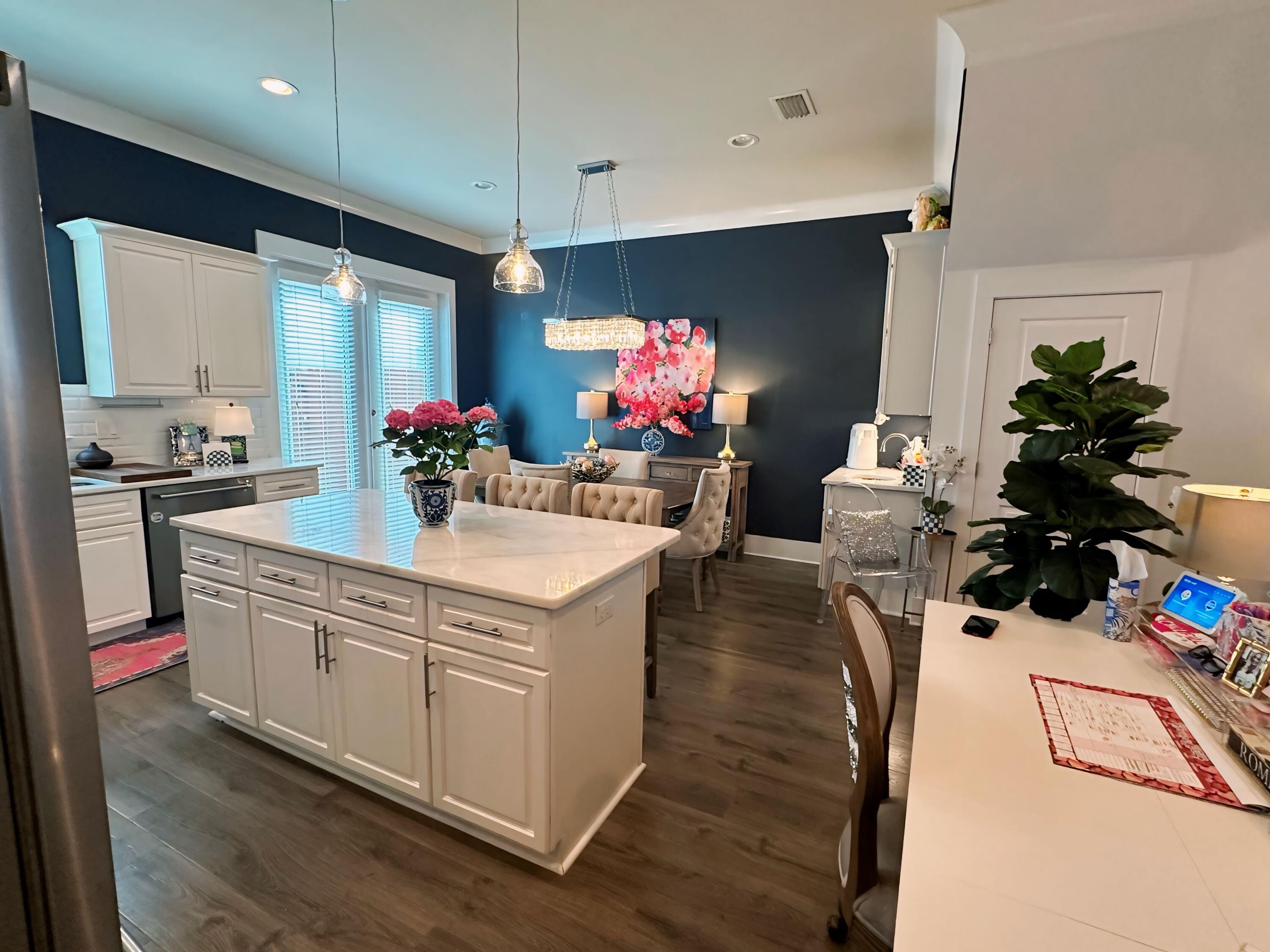 995 Airport Road, Unit 35 Destin, FL 32541 - Photo 4 of 15 a kitchen with stainless steel appliances kitchen island granite countertop a sink dishwasher and white cabinets with wooden floor