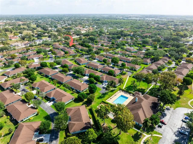an aerial view of residential houses with outdoor space and trees