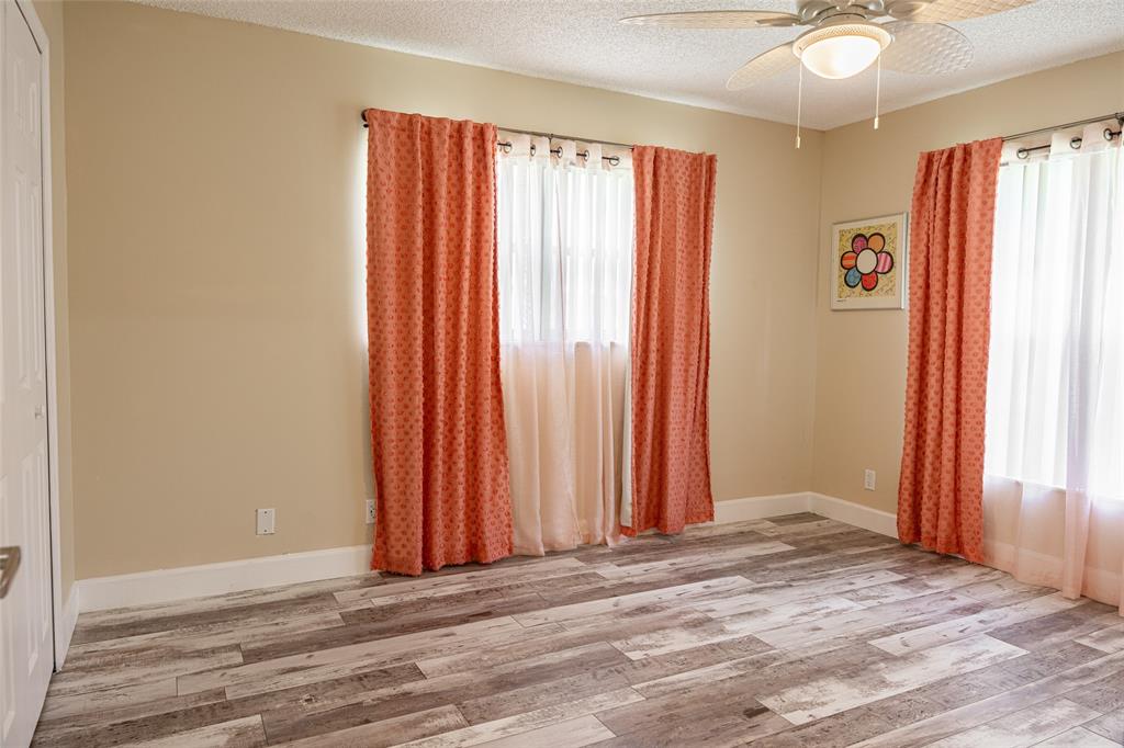 9870 Pecan Tree Drive, Unit B Boynton Beach, FL 33436 - Photo 23 of 33 an empty room with wooden floor and a window