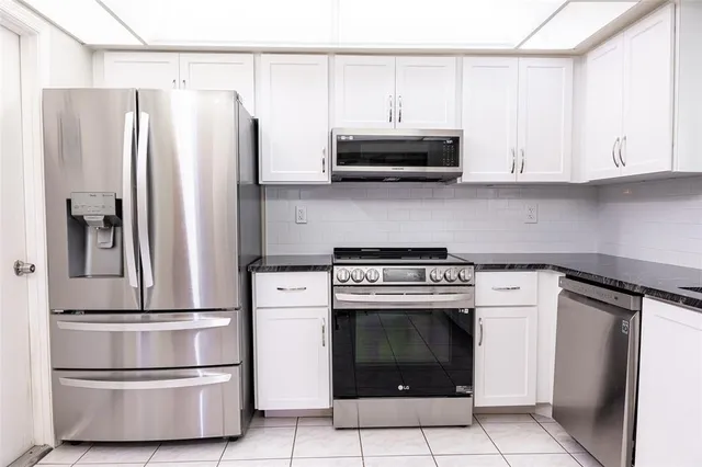 a kitchen with stainless steel appliances granite countertop a refrigerator sink and microwave