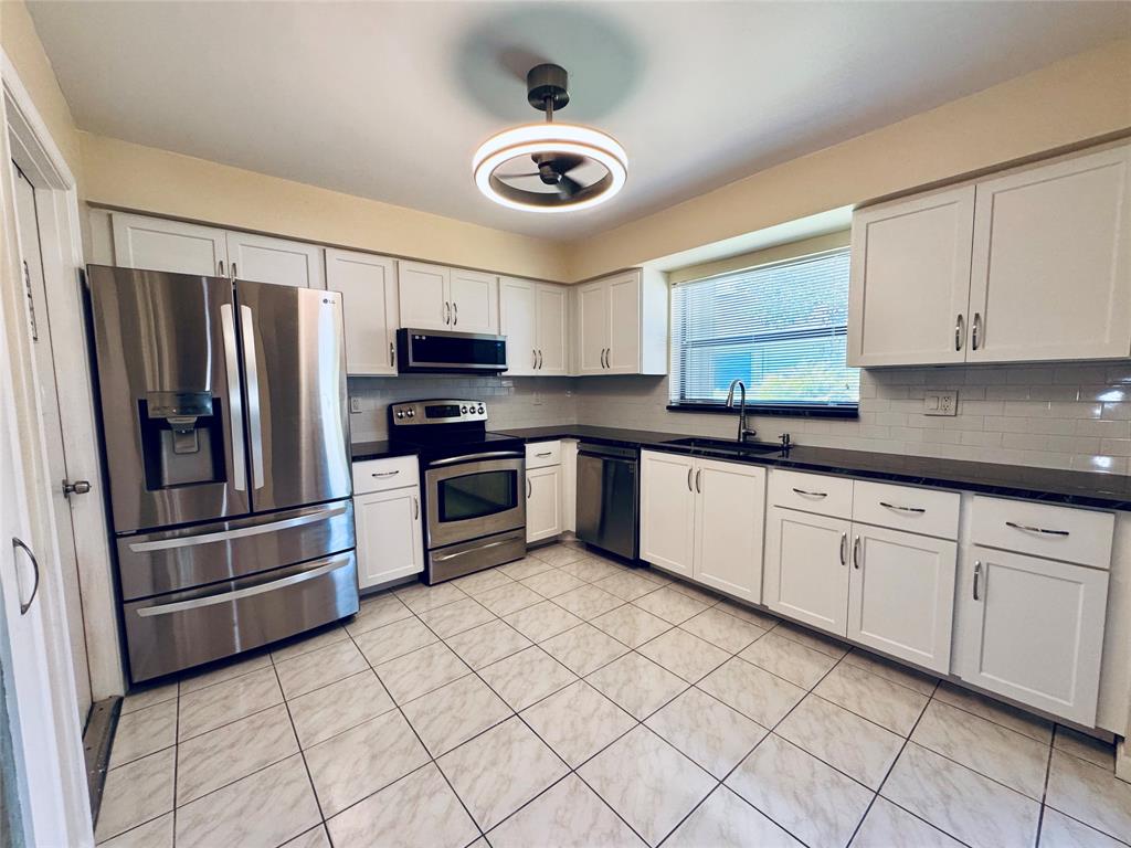 9870 Pecan Tree Drive, Unit B Boynton Beach, FL 33436 - Photo 8 of 33 a kitchen with stainless steel appliances granite countertop a refrigerator sink and microwave