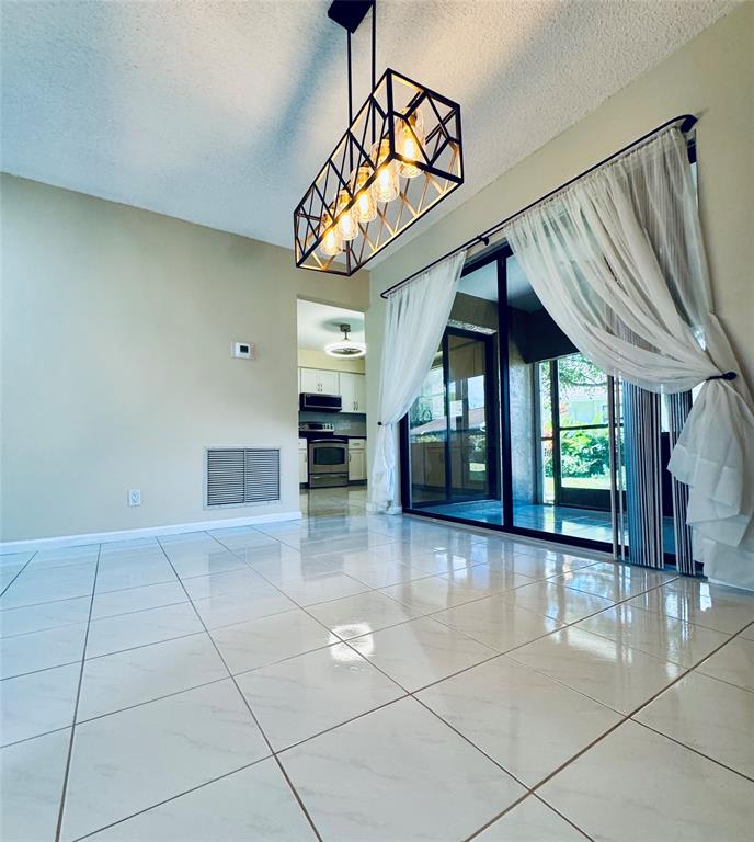 9870 Pecan Tree Drive, Unit B Boynton Beach, FL 33436 - Photo 10 of 33 a view of an entryway with a chandelier