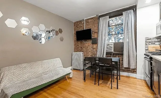 a living room with furniture a flat screen tv and a floor to ceiling window