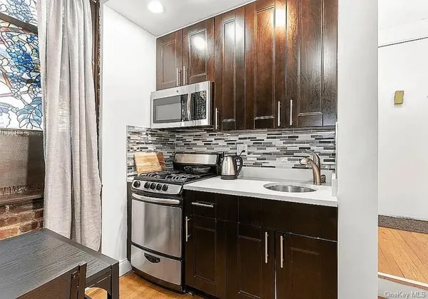 a kitchen with kitchen island granite countertop a sink stainless steel appliances and cabinets