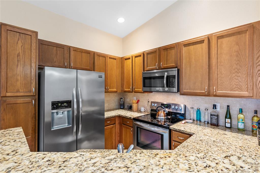 3067 Laurel Ridge Circle Riviera Beach, FL 33404 - Photo 13 of 27 a kitchen with stainless steel appliances granite countertop a refrigerator a stove top oven a sink and dishwasher