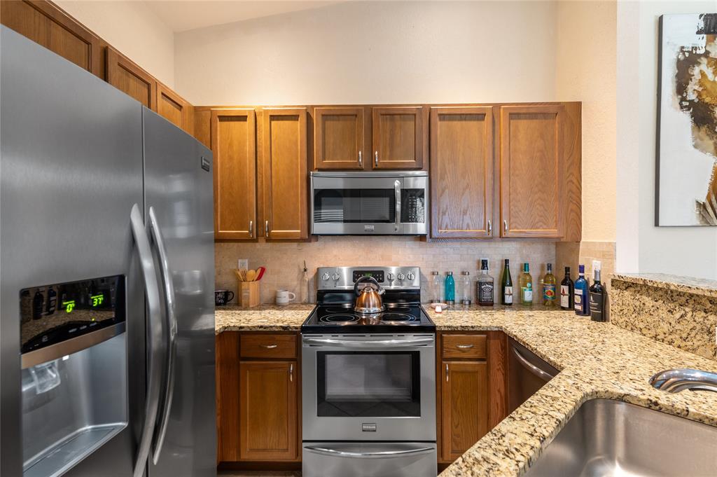 3067 Laurel Ridge Circle Riviera Beach, FL 33404 - Photo 15 of 27 a kitchen with stainless steel appliances granite countertop a refrigerator stove and sink