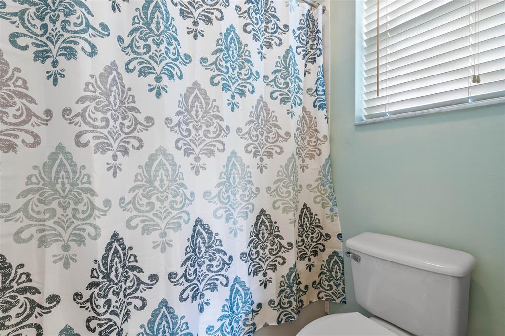 3067 Laurel Ridge Circle Riviera Beach, FL 33404 - Photo 21 of 27 a white toilet sitting next to a shower curtain