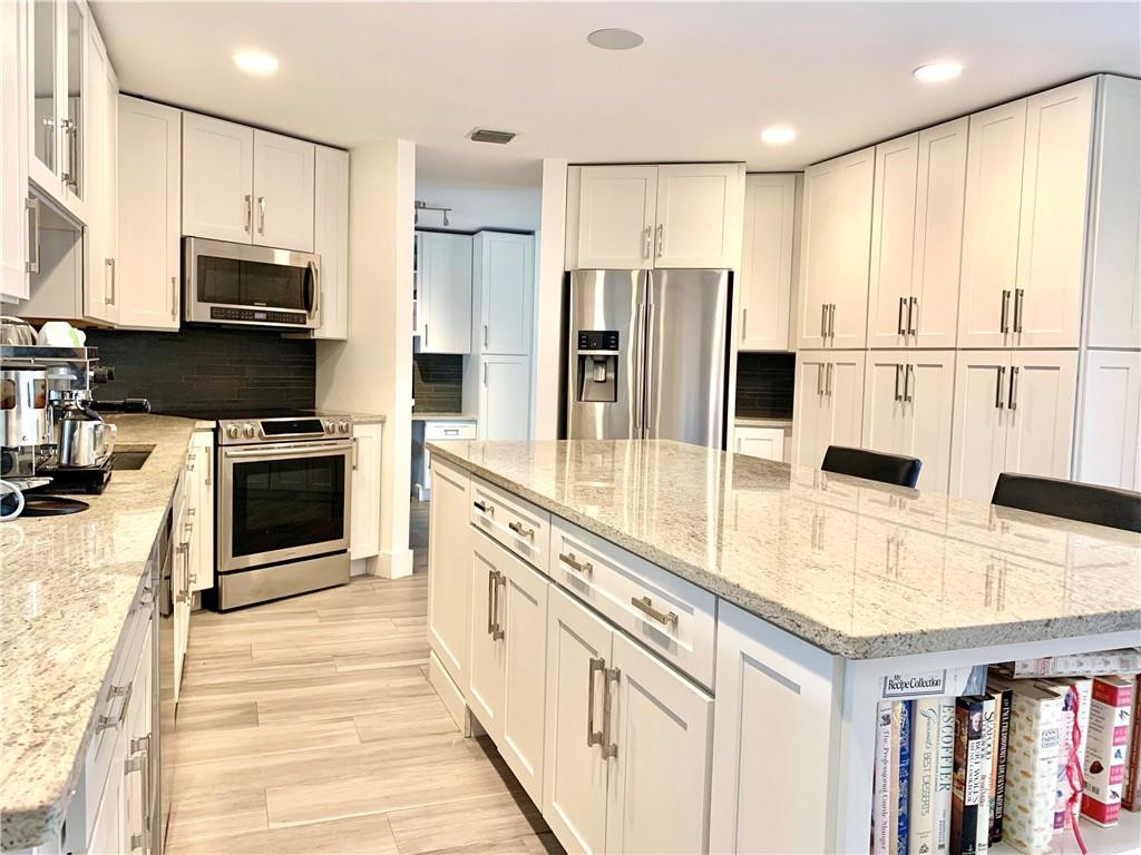 23336 Water Circle Boca Raton, FL 33486 - Photo 6 of 50 a kitchen with stainless steel appliances a stove sink microwave and cabinets
