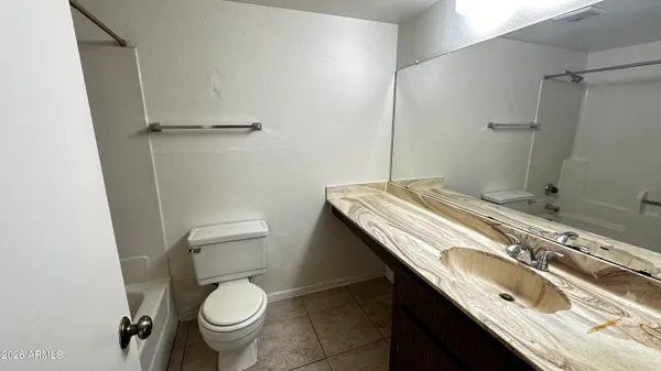 a bathroom with a granite countertop toilet sink and mirror