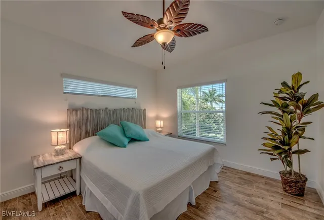 a bedroom with a bed potted plant on table and a window