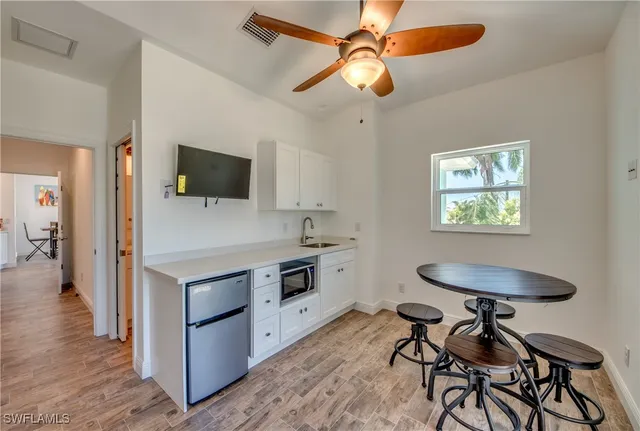 a kitchen with a table chairs refrigerator and microwave
